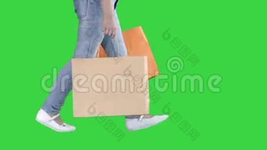 <strong>活泼开朗</strong>的女孩带着购物袋走在绿色屏幕上，Chroma键。
